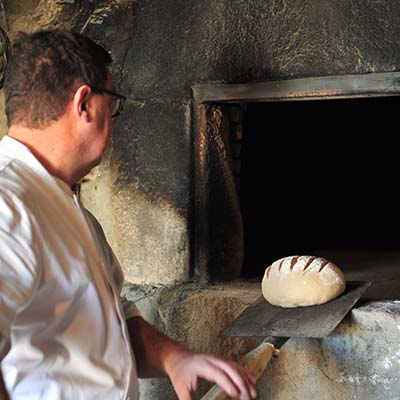 Enfournage d'une miche dans un four à pain à La Remaudière